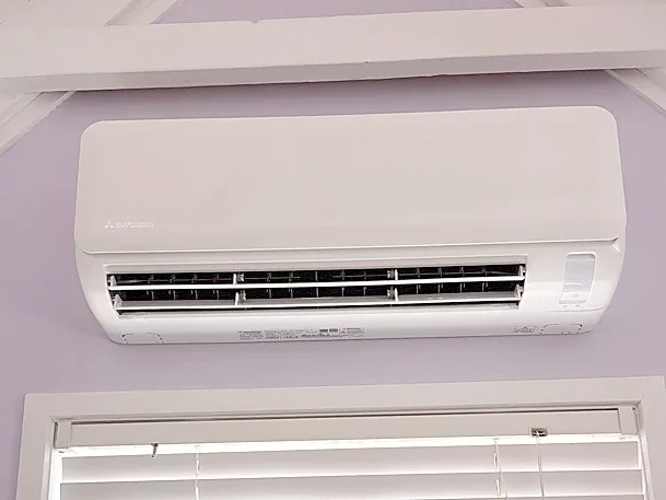 Split system installed in a lavender bedroom above the window