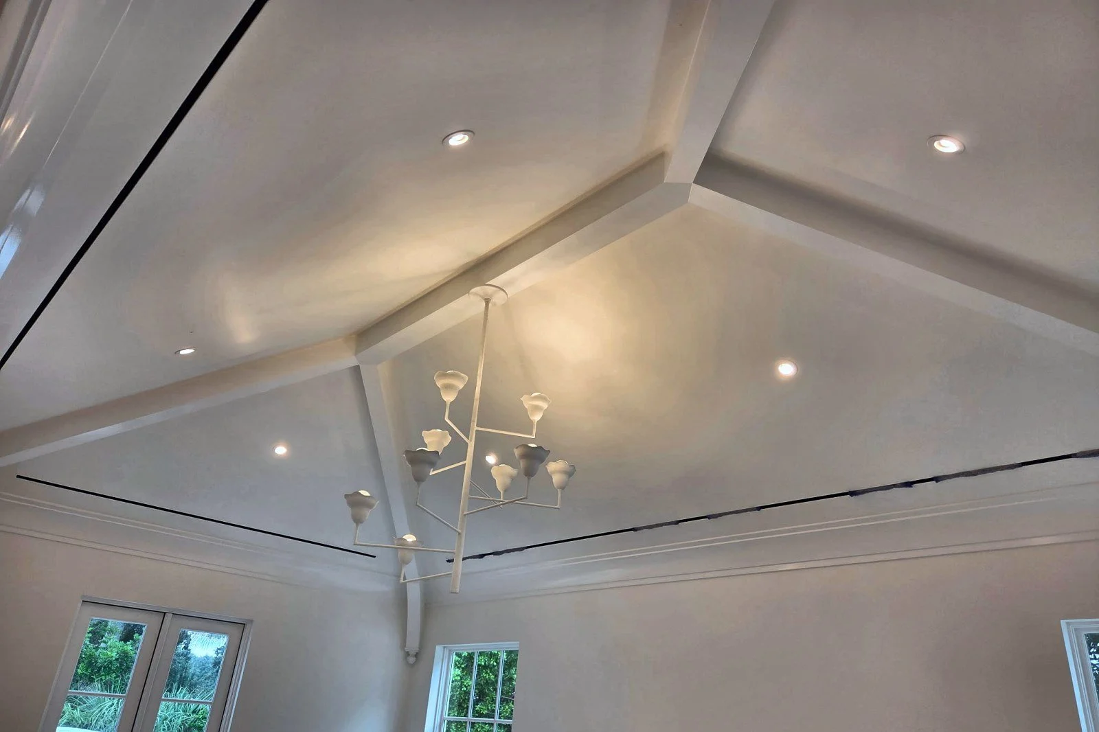 Vaulted ceiling in a custom home with recessed lighting and a chandelier