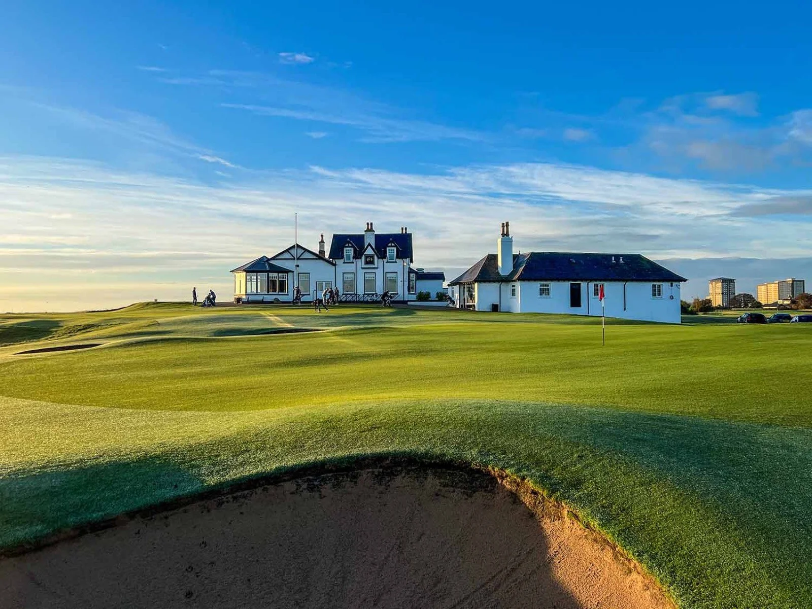 The home green and whitewashed clubhouse at Royal Aberdeen in low evening sun