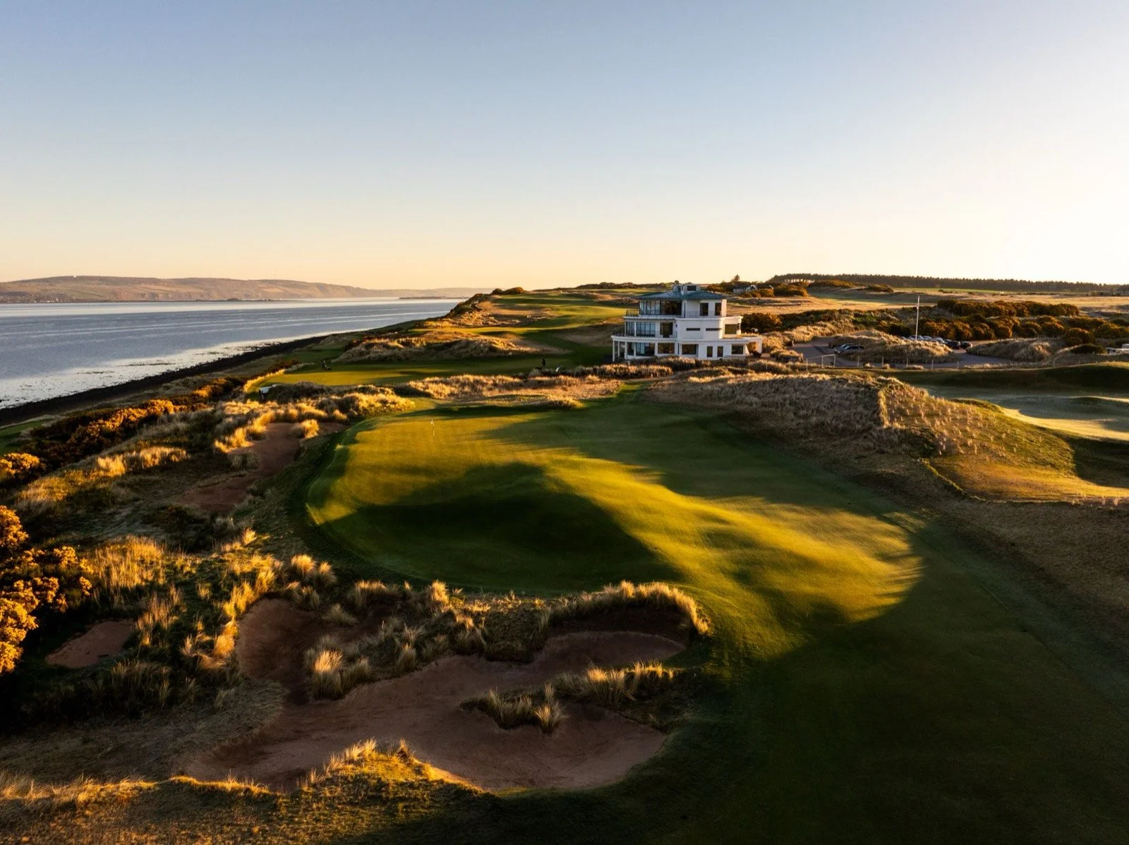 The Art Deco clubhouse at Cabot Highlands above the Moray Firth at golden hour