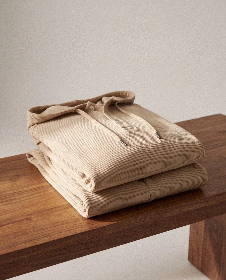 Folded knit hoodies on a bench