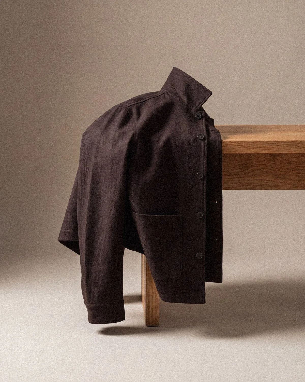Chore jacket draped over an oak bench
