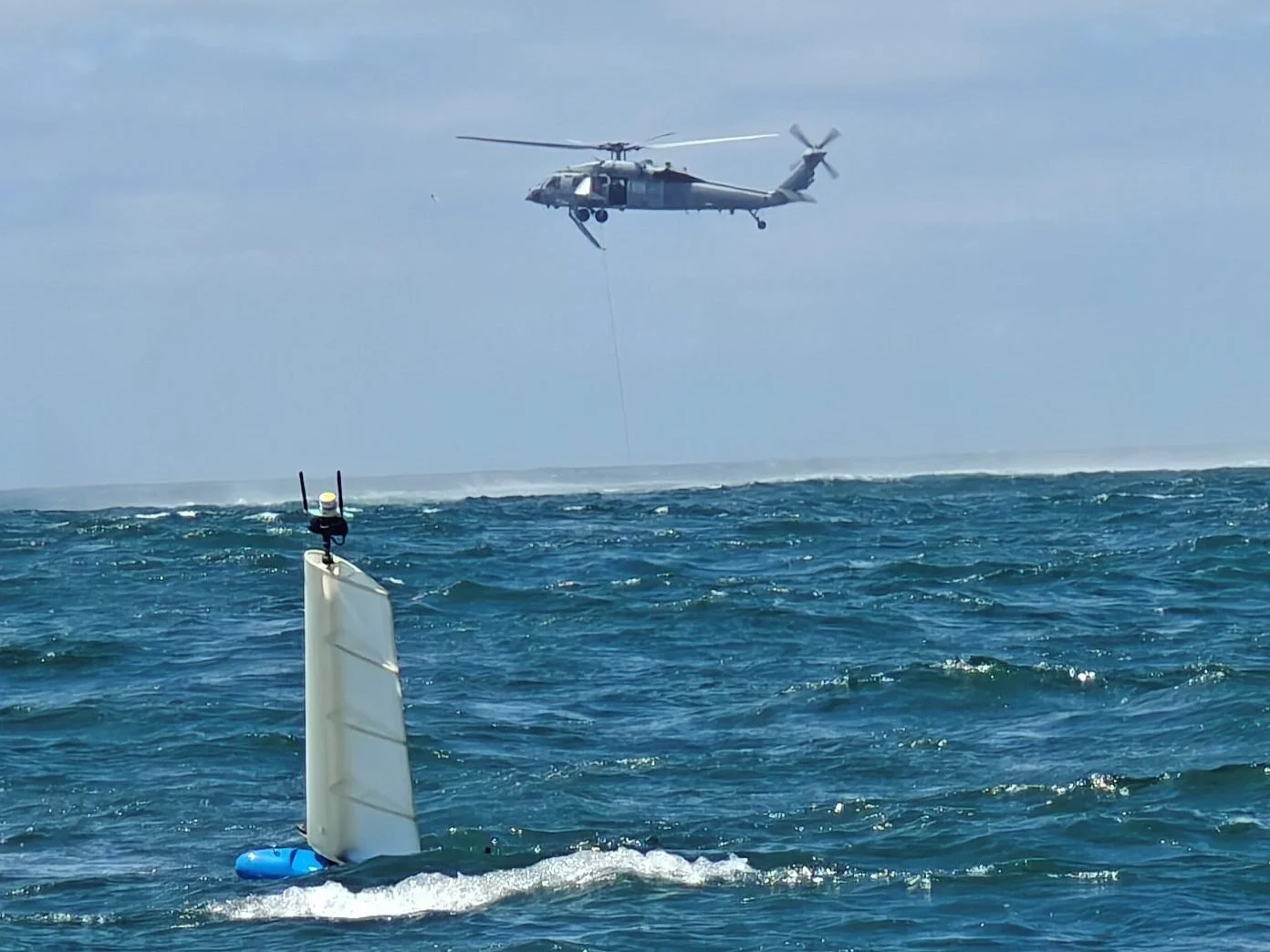 HORUS on station with a U.S. Navy helicopter overhead during MCM operations