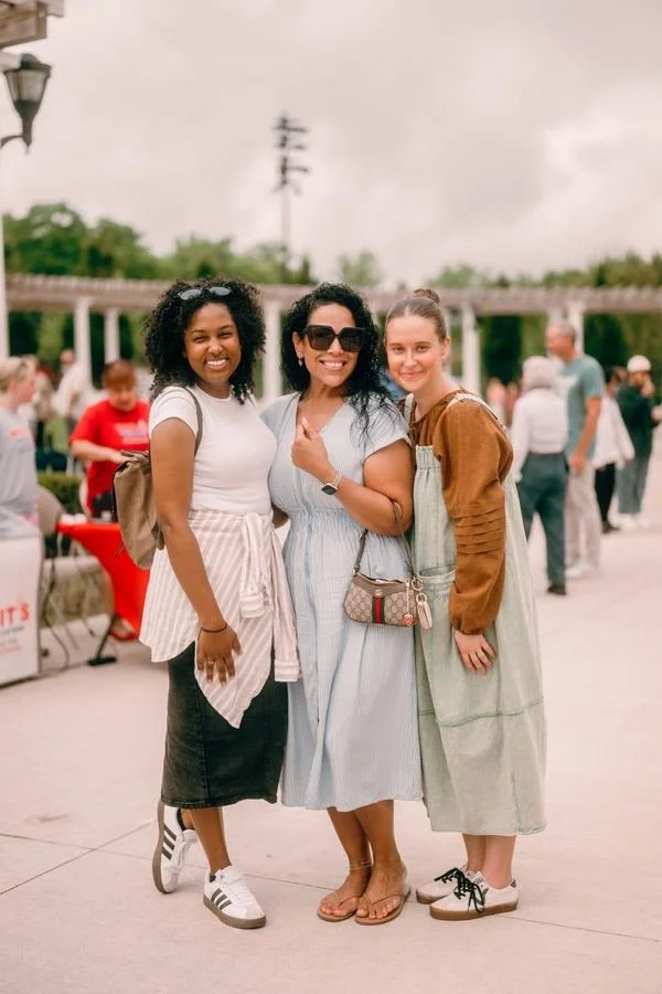 Three friends smiling together at an Infinite Church gathering