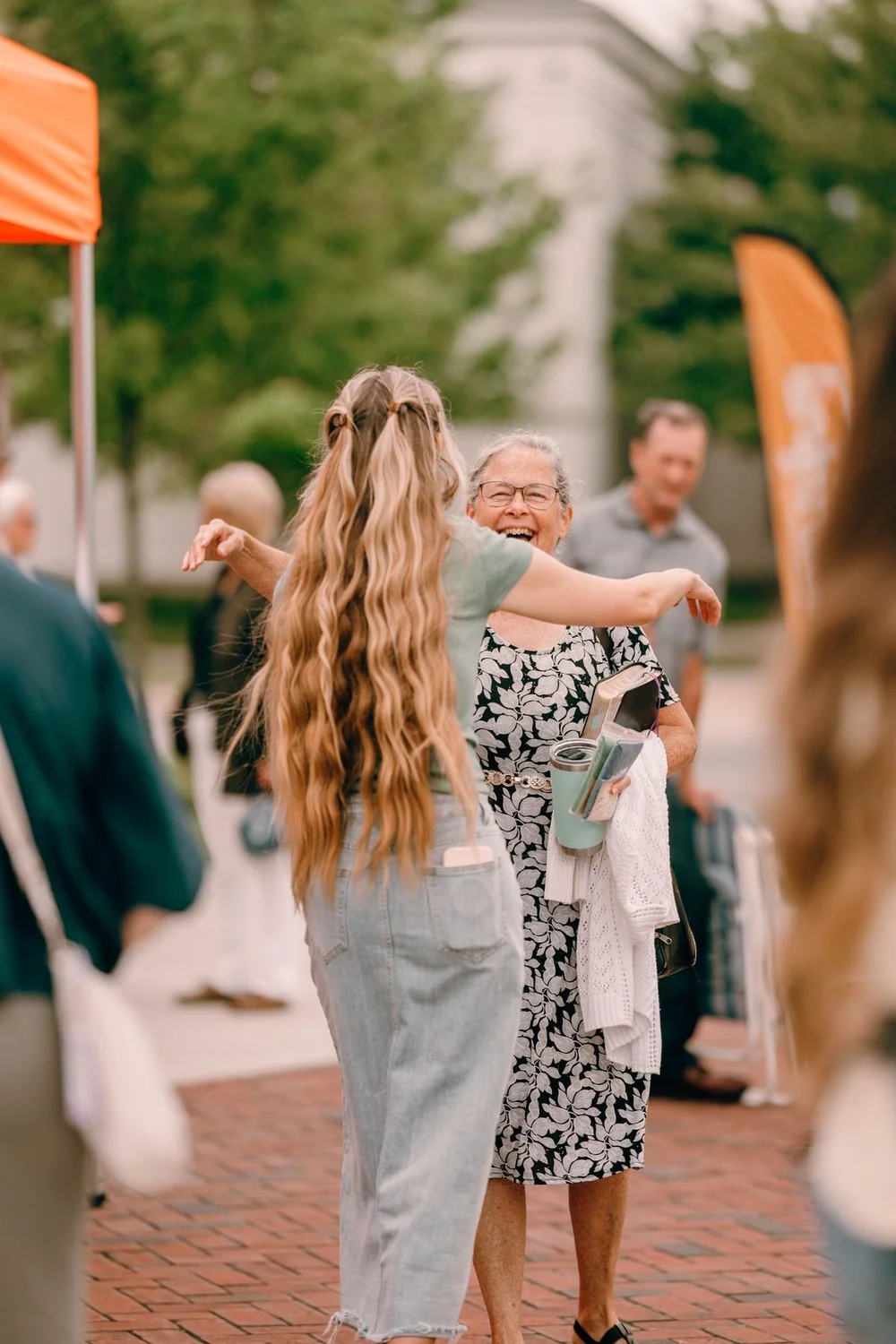 Two women greeting each other with a hug