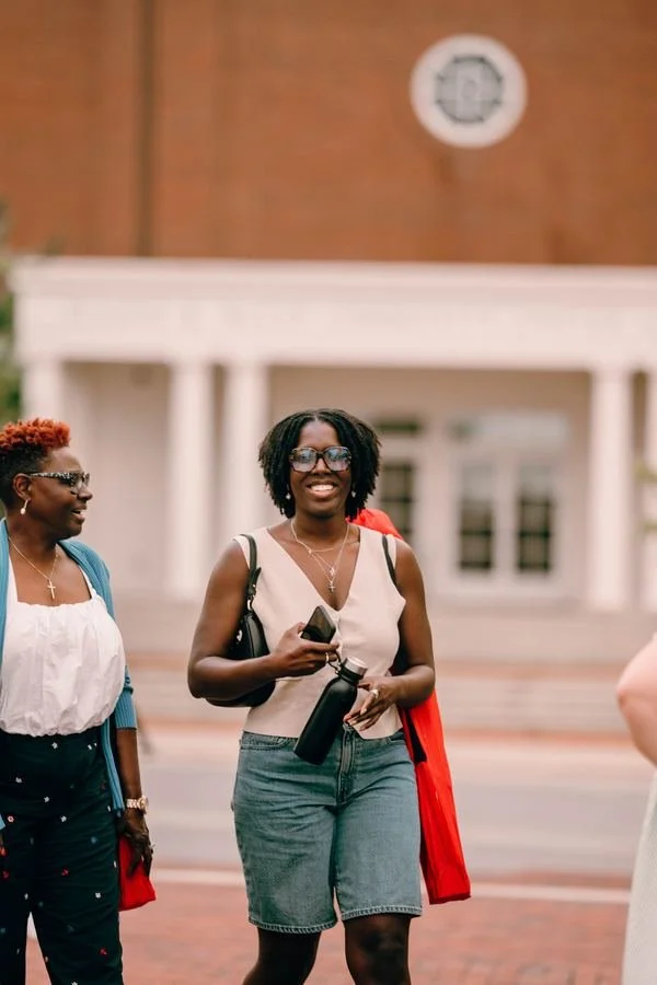 Two women smiling as they walk and talk