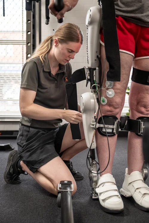 An exercise physiologist fitting the HAL exoskeleton