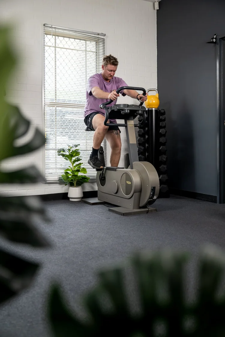 A client on an exercise bike in a clinic gym