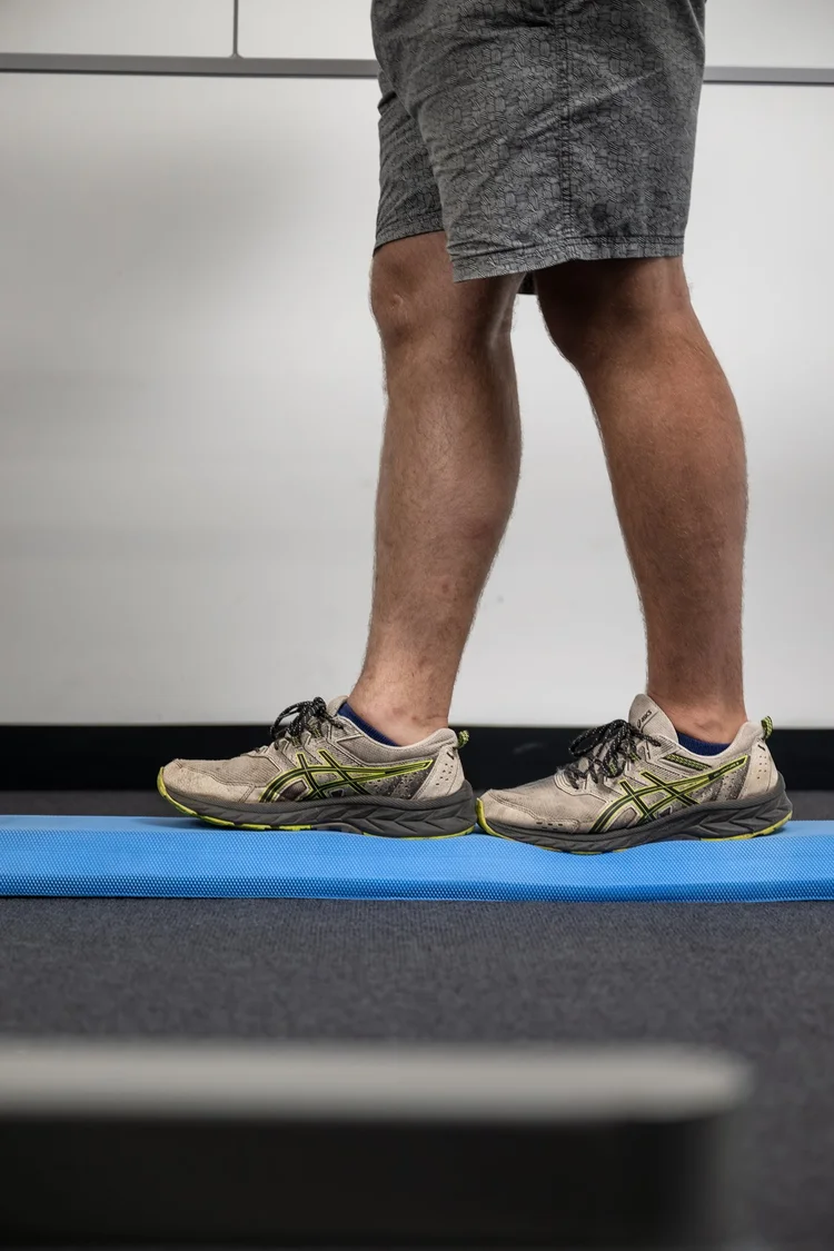 A client rebuilding balance on a foam beam