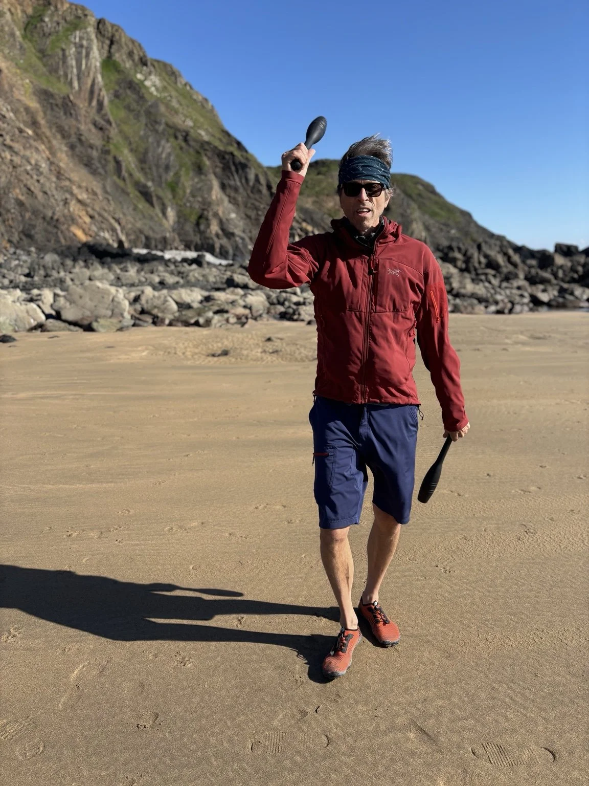 Ulric Whyte practising Indian Club swinging on a beach