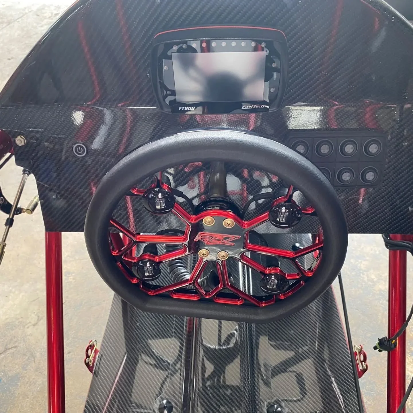 FuelTech dash and keypad in a carbon-fiber cockpit