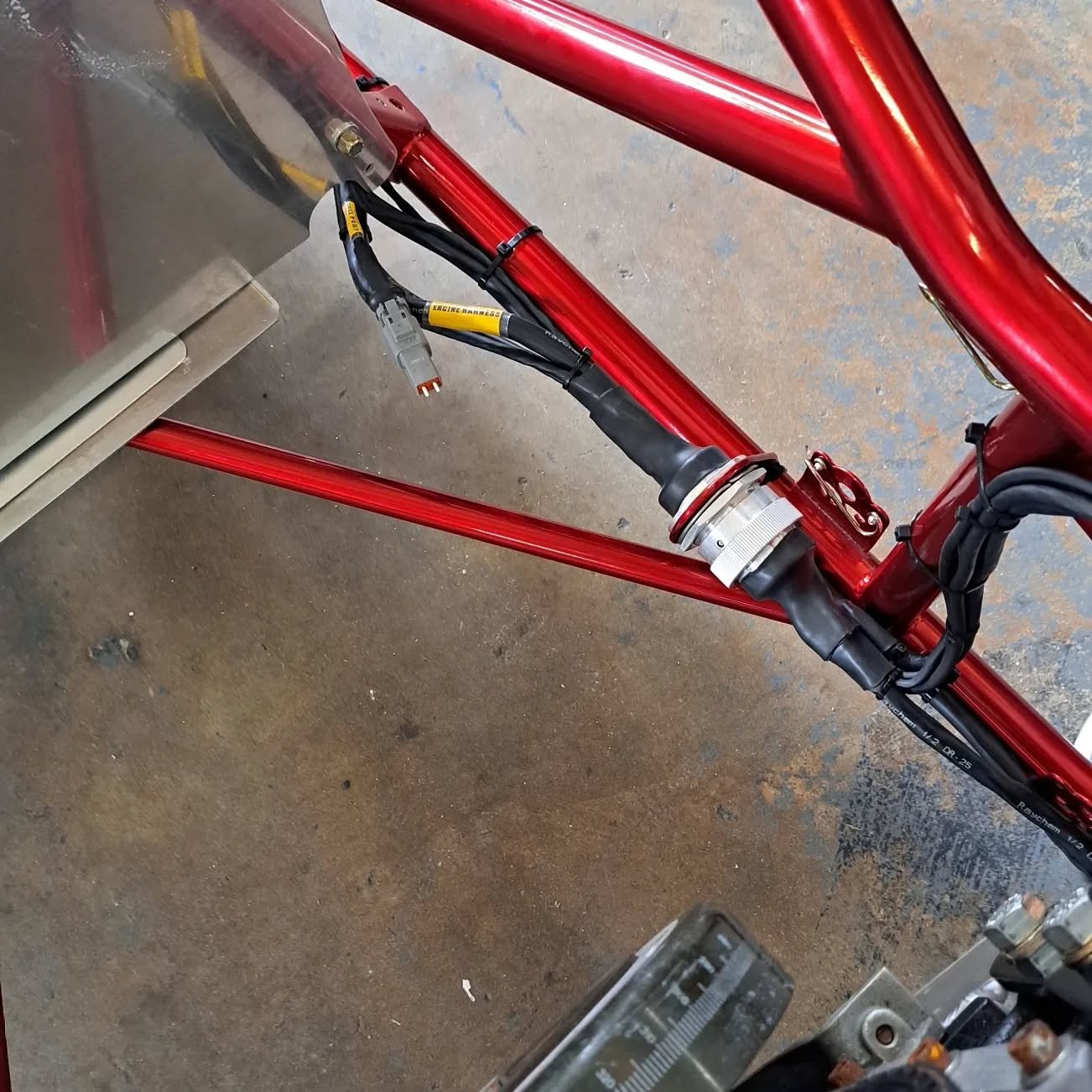 Circular bulkhead connector and labeled harness on a red chassis