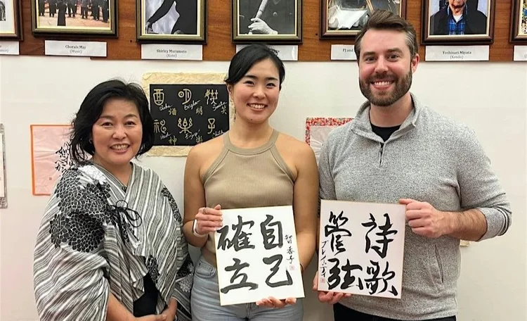 Photo of Sengoku-sensei with two students showing their Japanese calligraphy after her lesson.