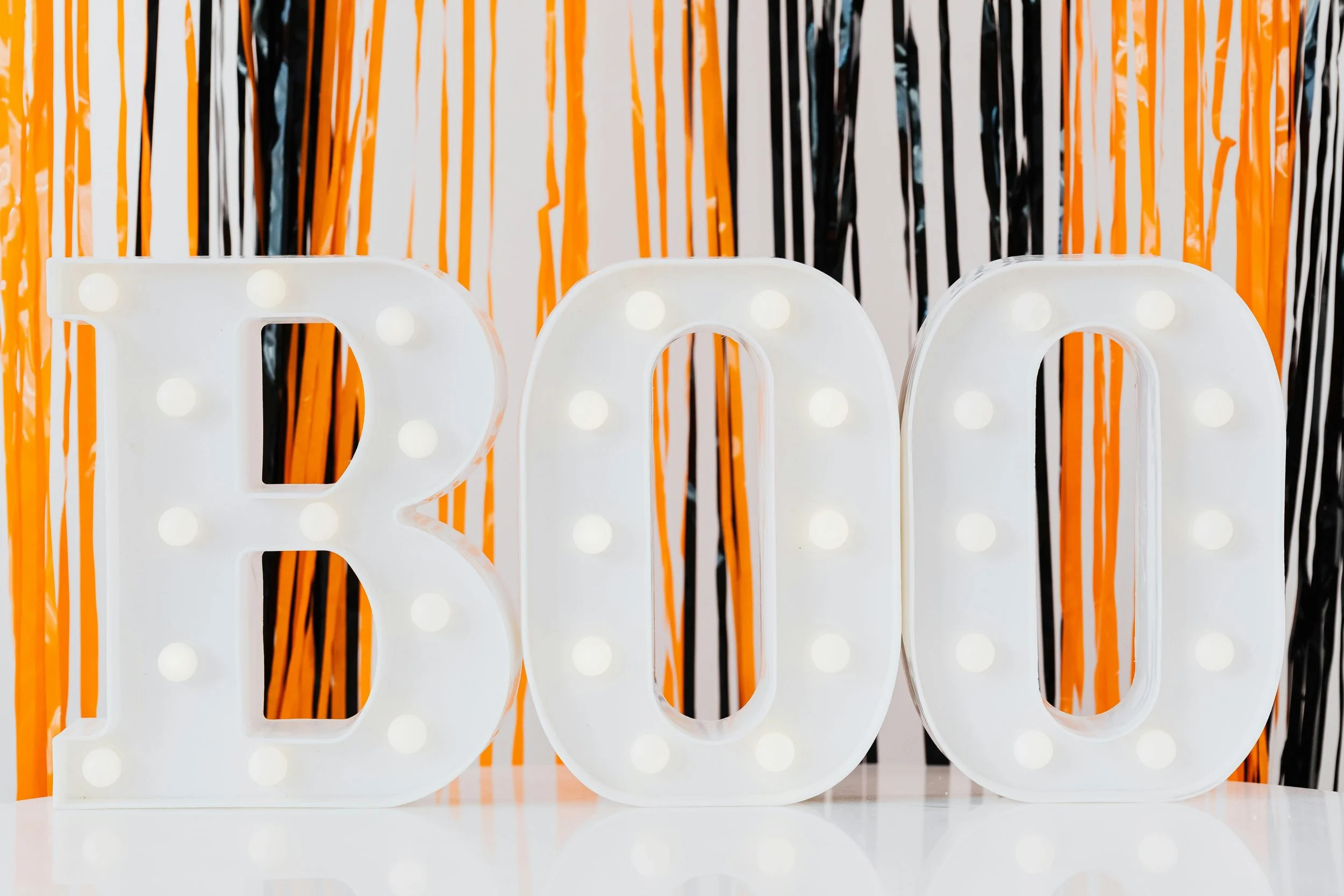 Violet and orange lighting with reflective dancefloor and BOO letters