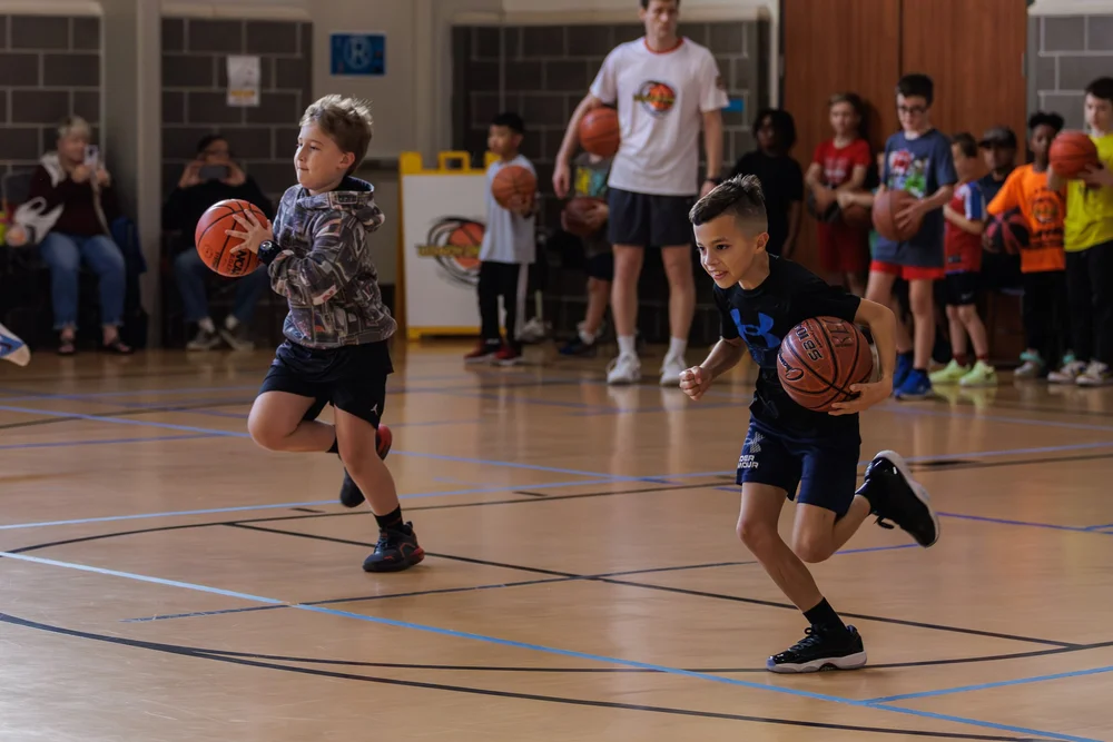 Players receiving structured basketball instruction from Coach Deon