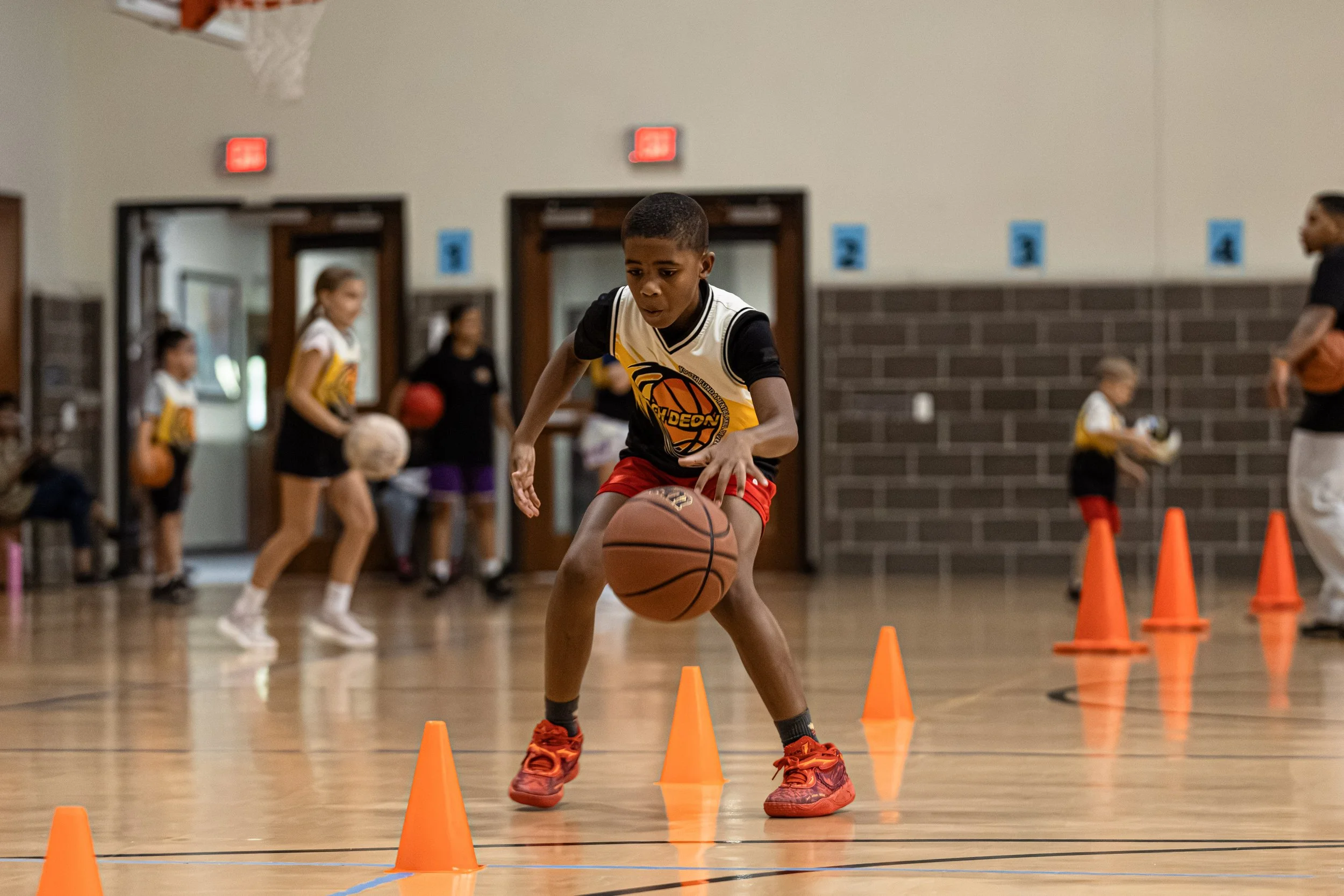 Coach Deon working with young basketball players during a structured development session