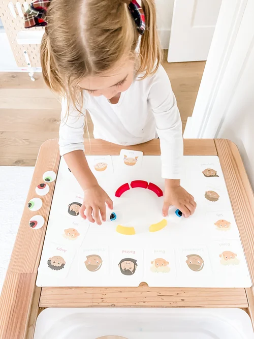 Toddler building a face on an emotions activity mat