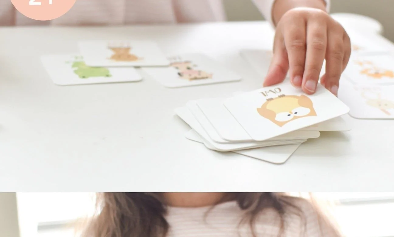 Toddler playing a face-up matching memory game, flipping a card to find its pair