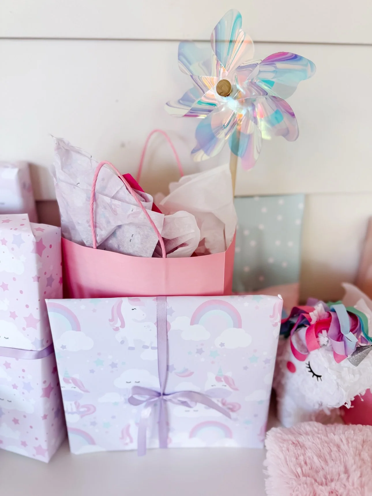 Sparkle like a Unicorn pennant tucked into a party gift bag with wrapped gifts