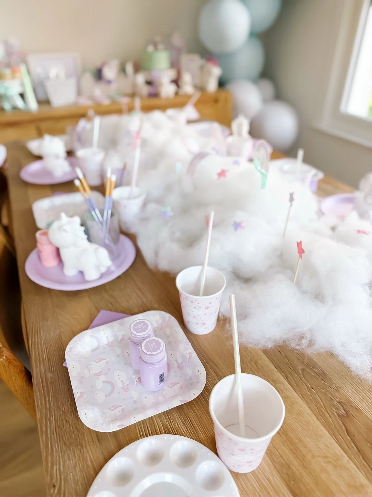 Paint-your-own ceramic unicorn activity table with paint pots and brushes