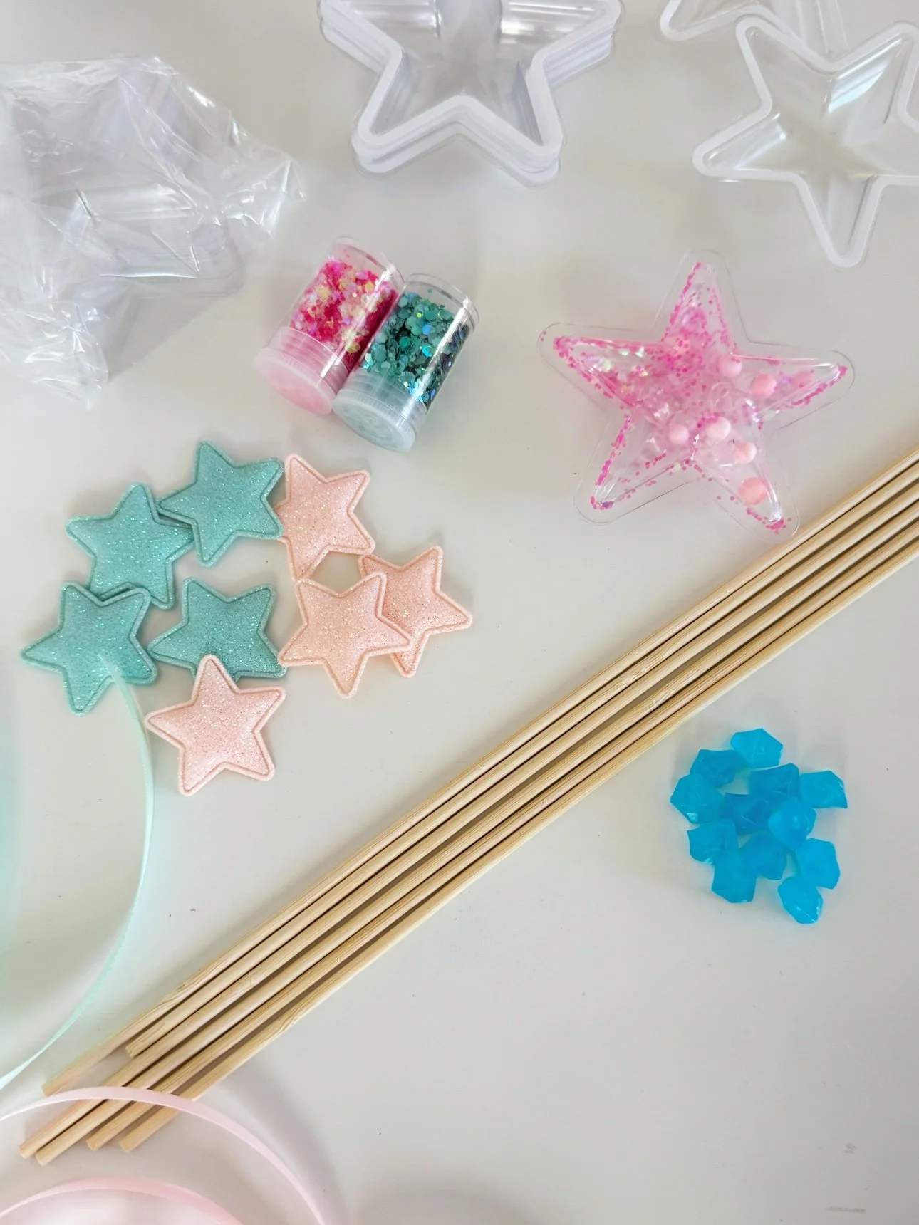 Star shaker wand craft supplies: clear star ornaments, wooden dowels, glitter, ribbon, foam stars