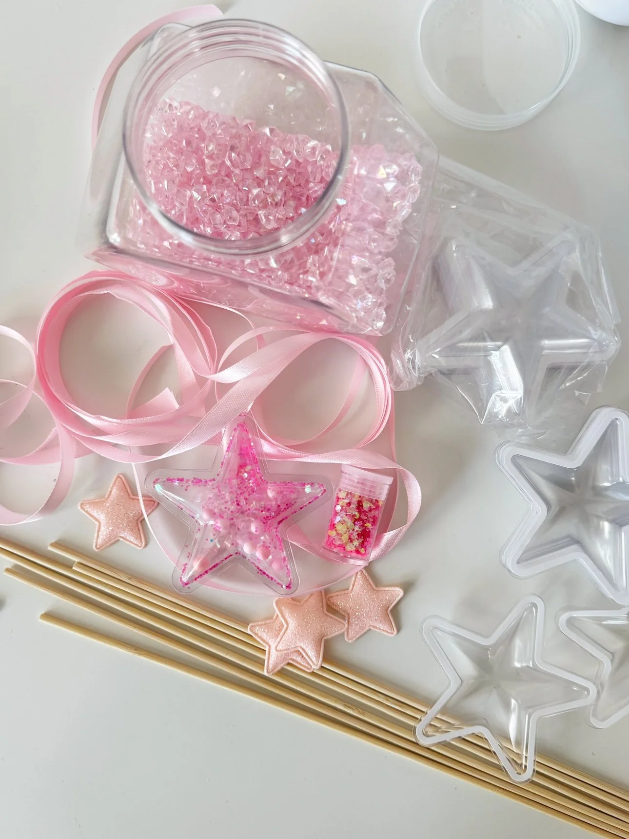 Pink glitter and beads ready to fill a clear star ornament