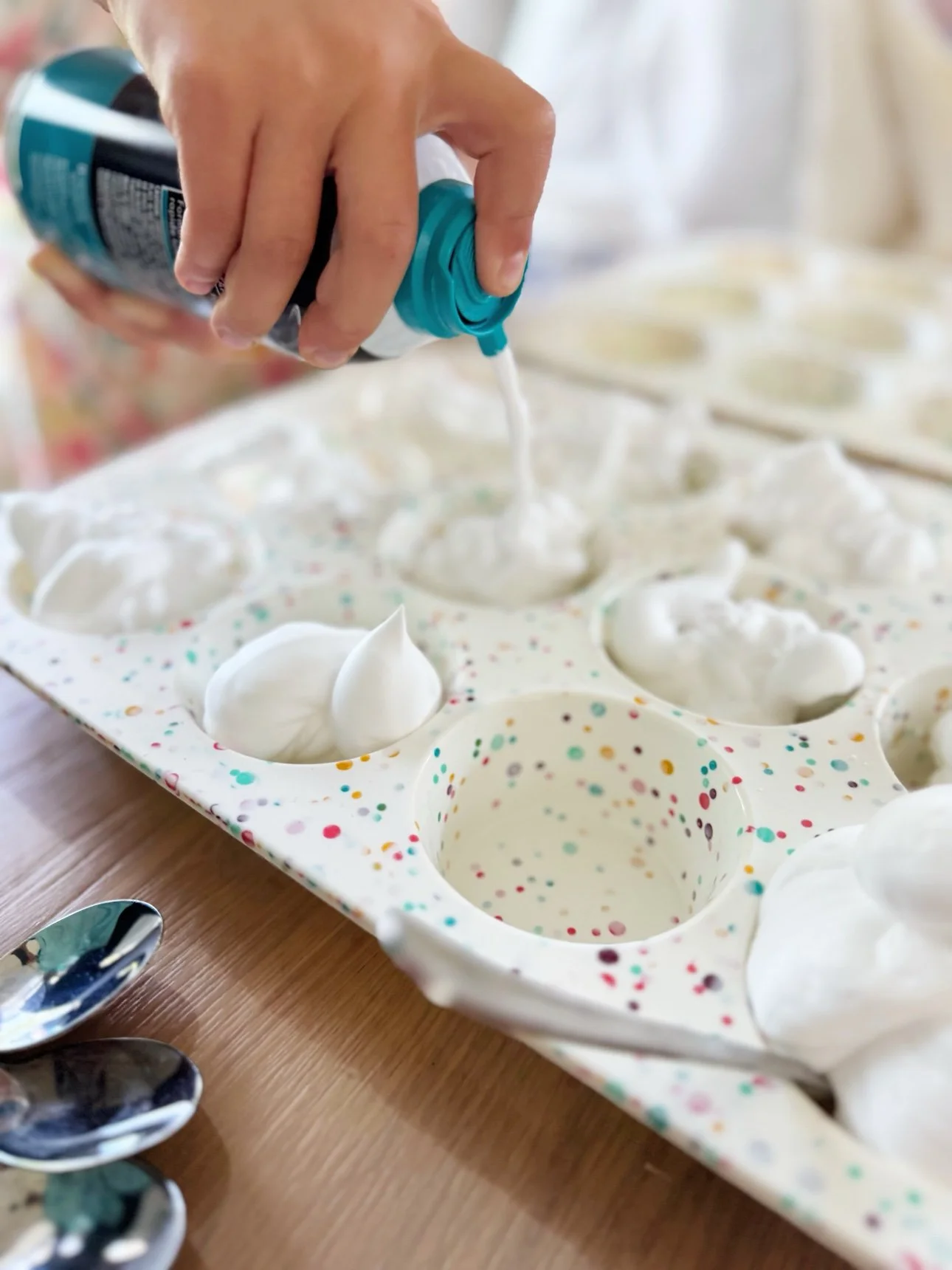 Spraying white shaving foam into a muffin tin