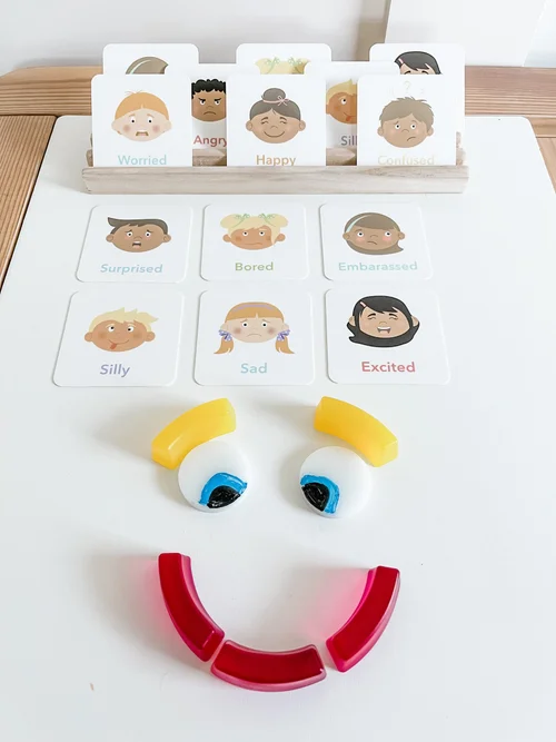 Toddler playing with emotions flashcards at a table