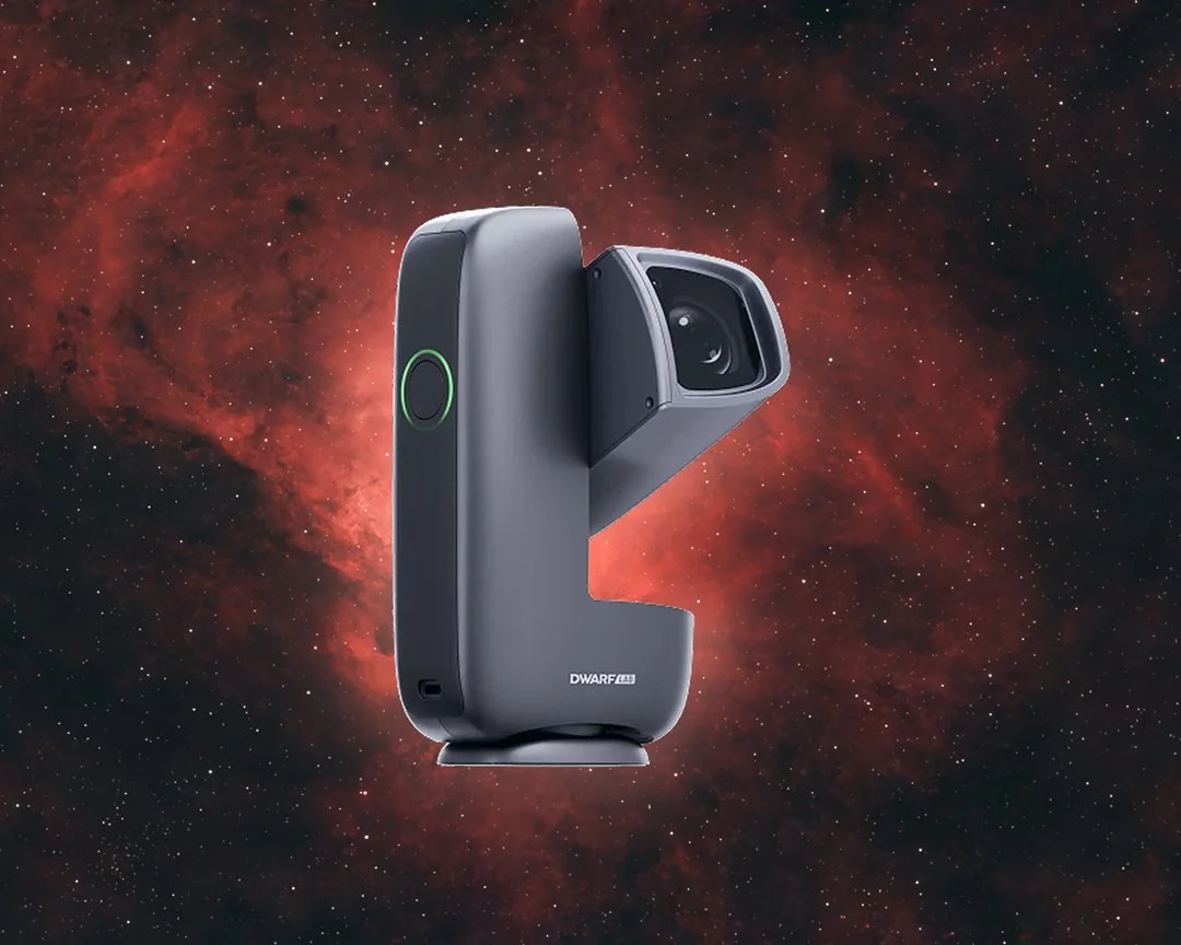 A DWARF Mini smart telescope in front of a red emission nebula.