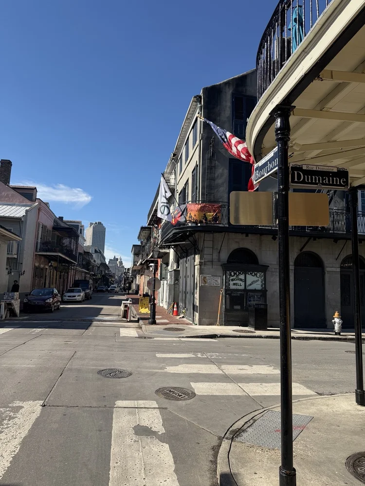 Historic buildings and iron balconies at the corner of Bourbon and Dumaine in New Orleans