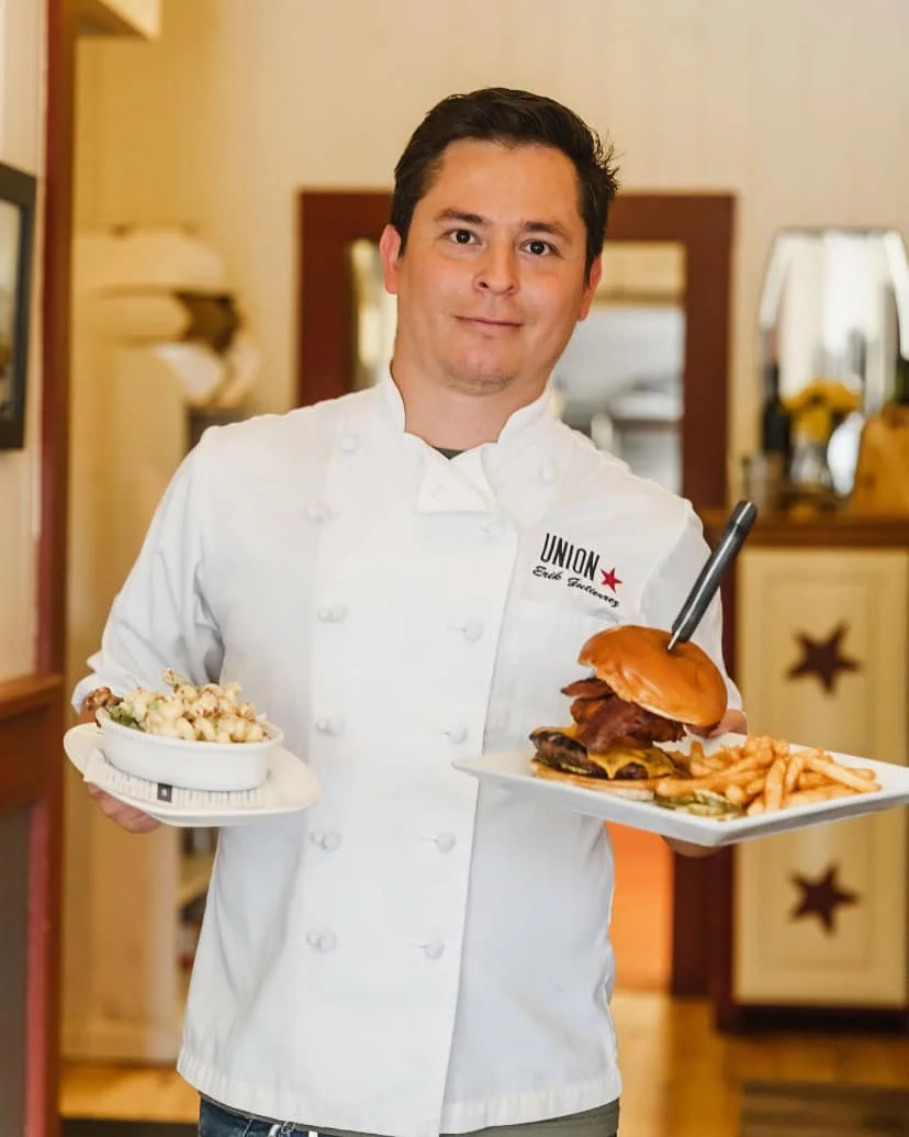 Chef Erik Gutierrez holding a bacon cheeseburger and Union Mac at Volcano Union Pub + Restaurant
