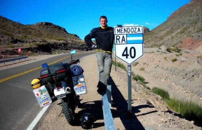 Paul with his motorcycle next to a Ruta 40 sign in Mendoza, Argentina