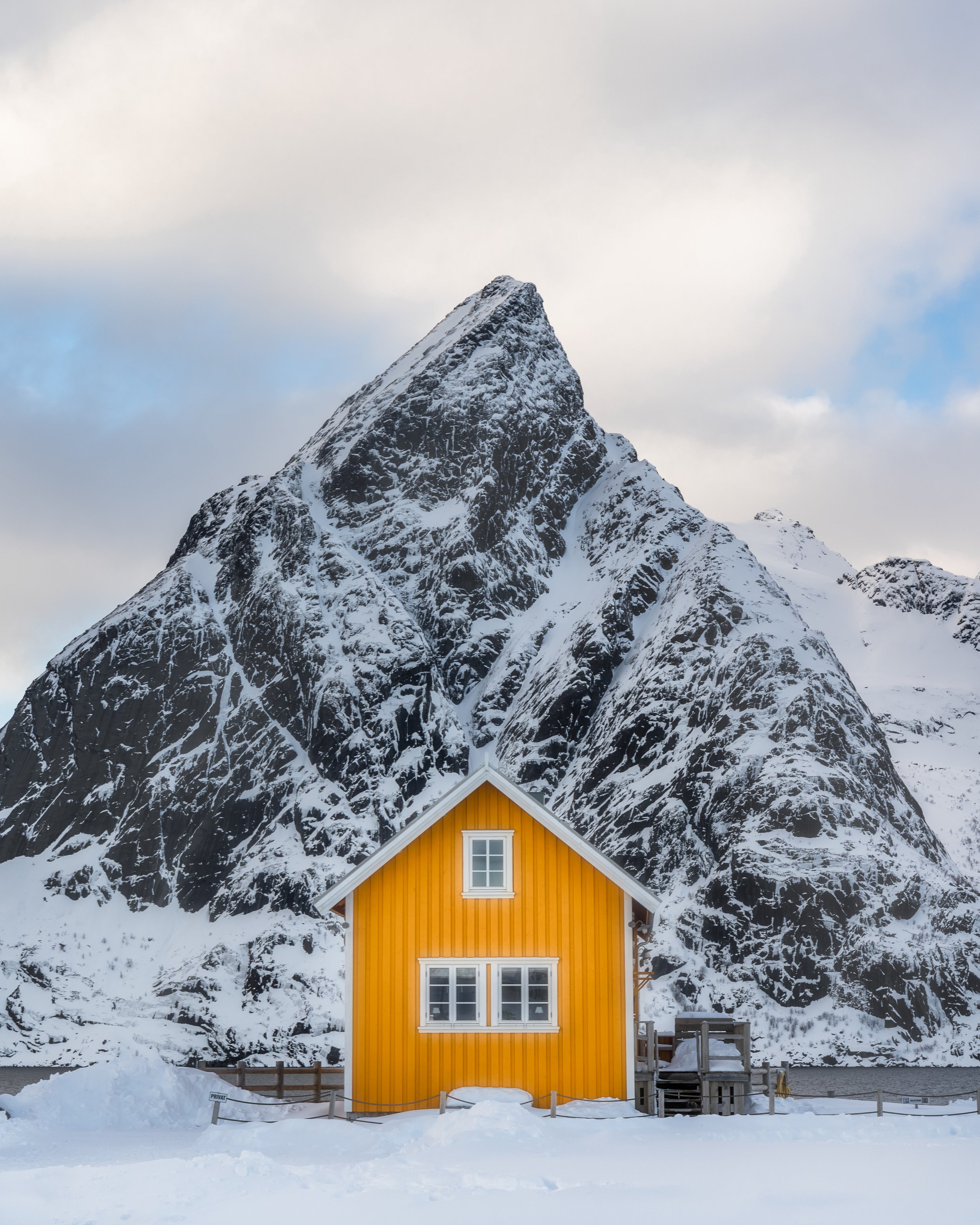 Sakrisøy yellow house with mountain backdrop — Lofoten photography