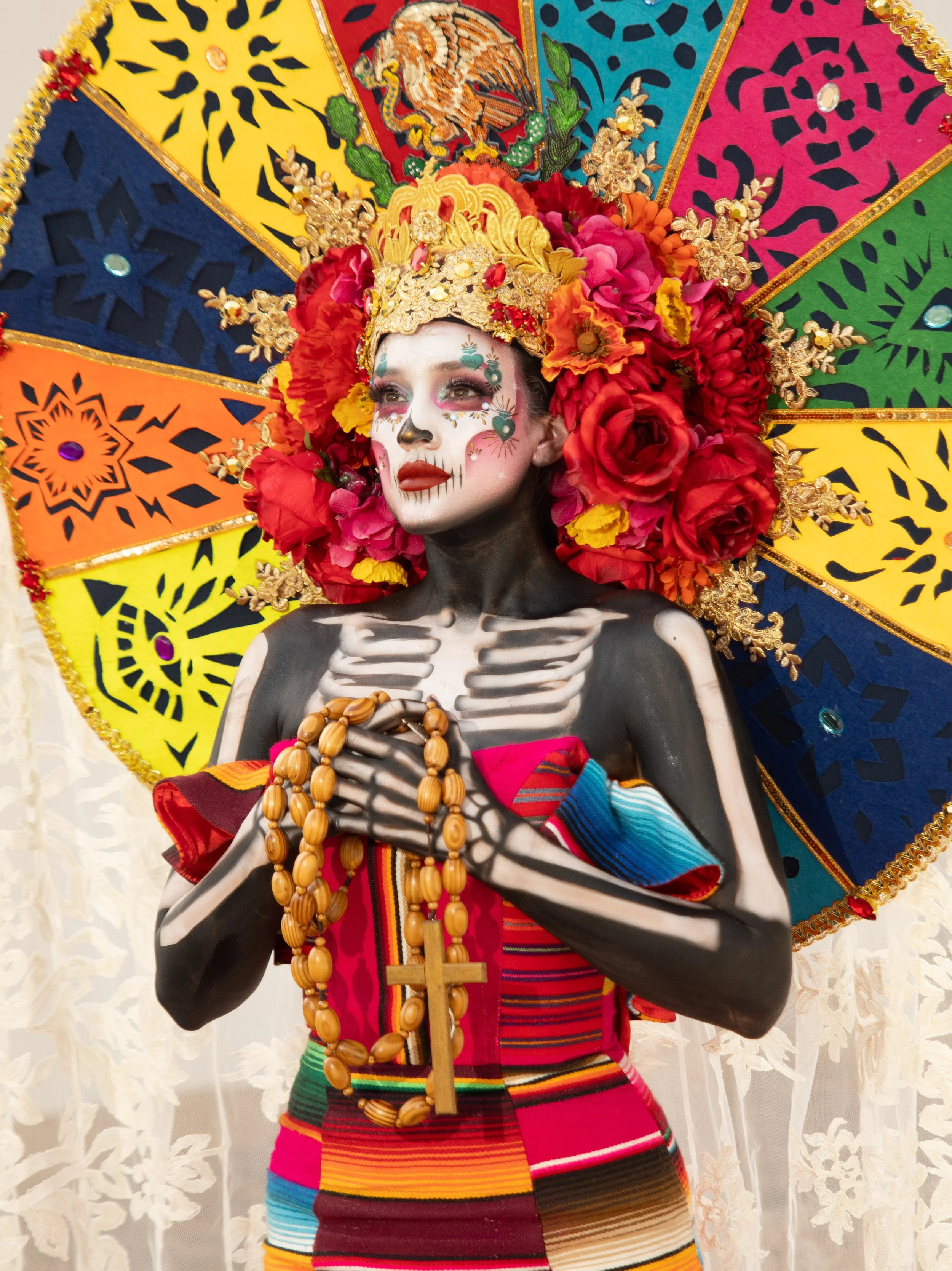 Close portrait of a Catrina model in a colorful headdress and traditional dress