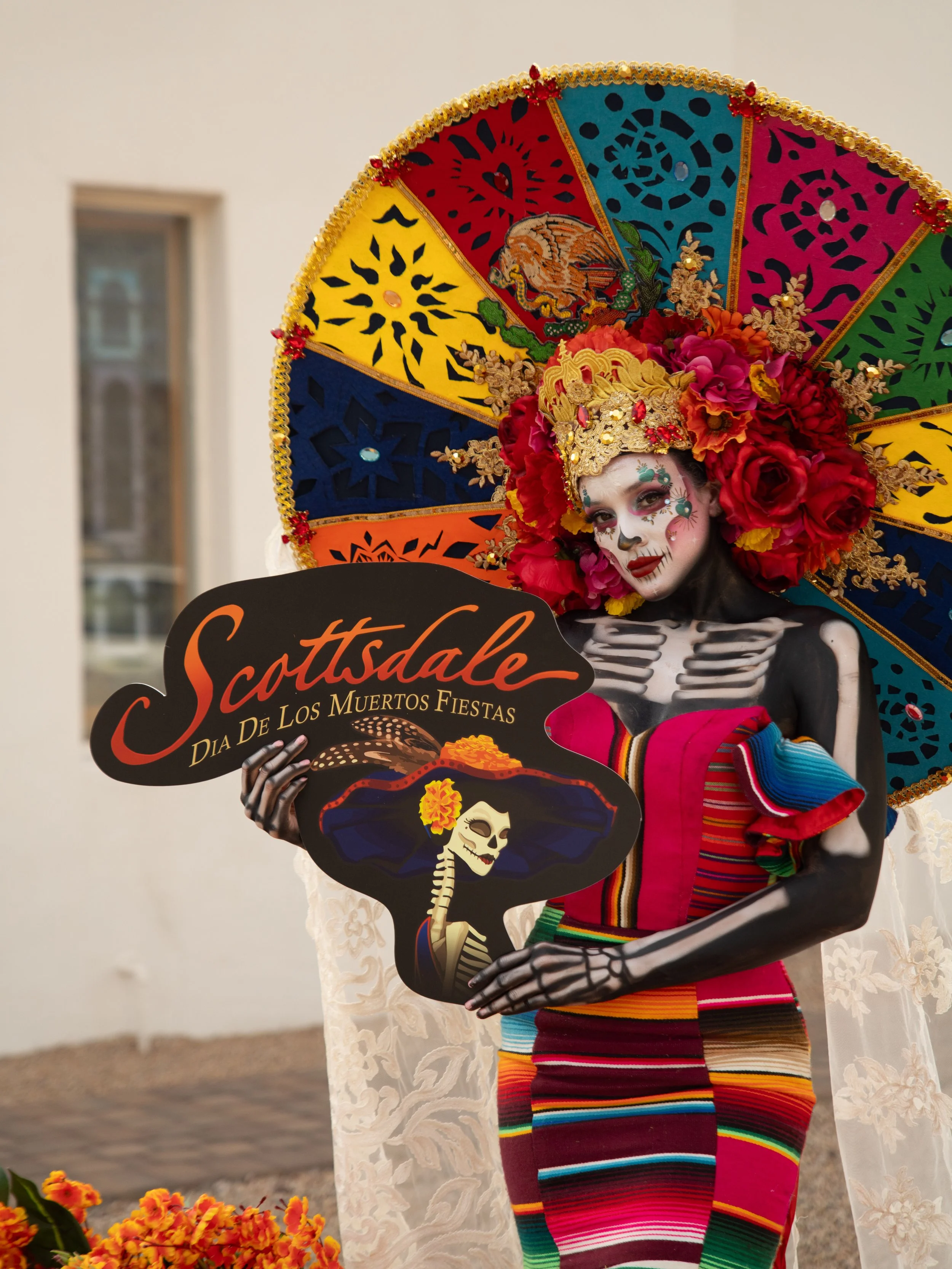 Catrina model holding a Scottsdale Día de los Muertos Fiestas sign