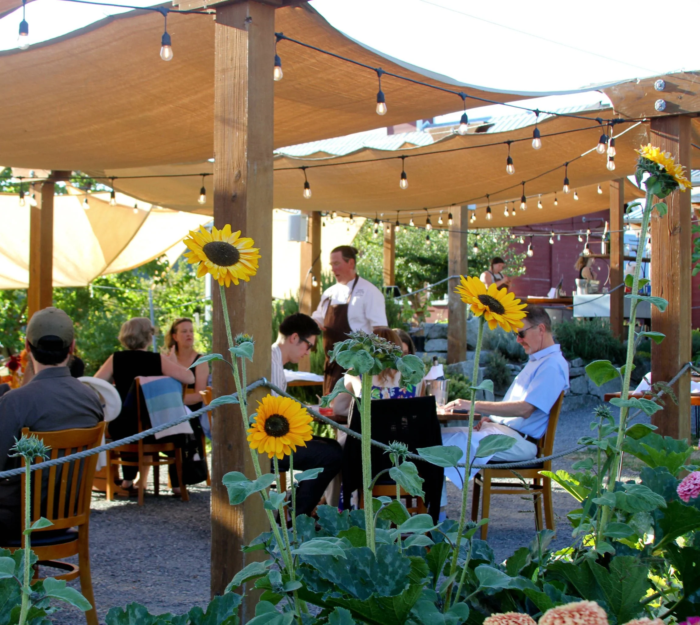 People dining around large wooden table at Orchard Kitchen