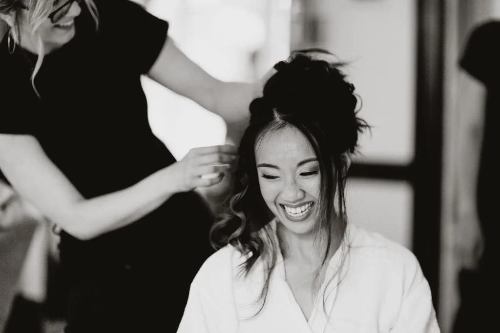Bride having her hair styled on her wedding morning