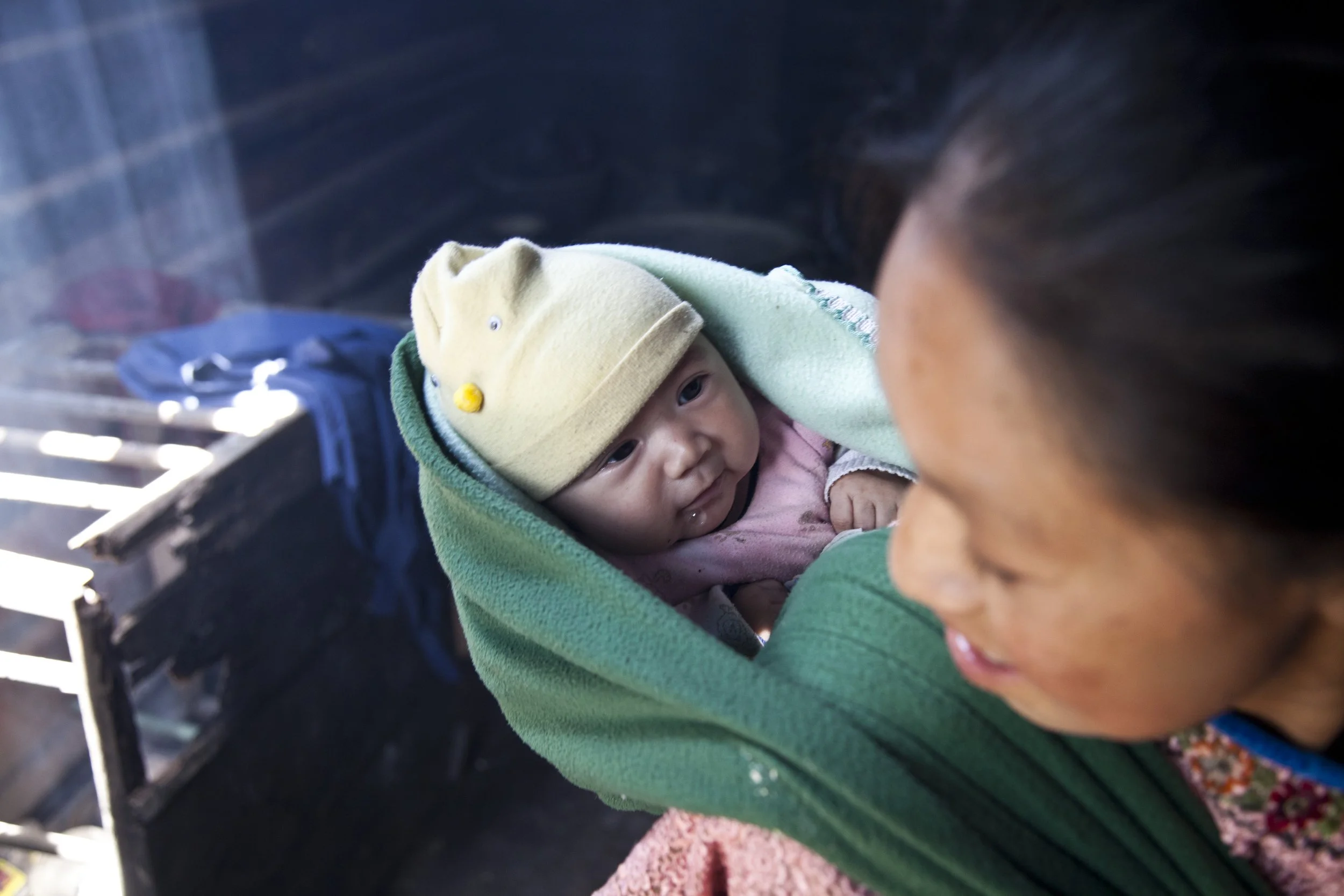 A mother holding her newborn at the El Arado Prenatal Clinic