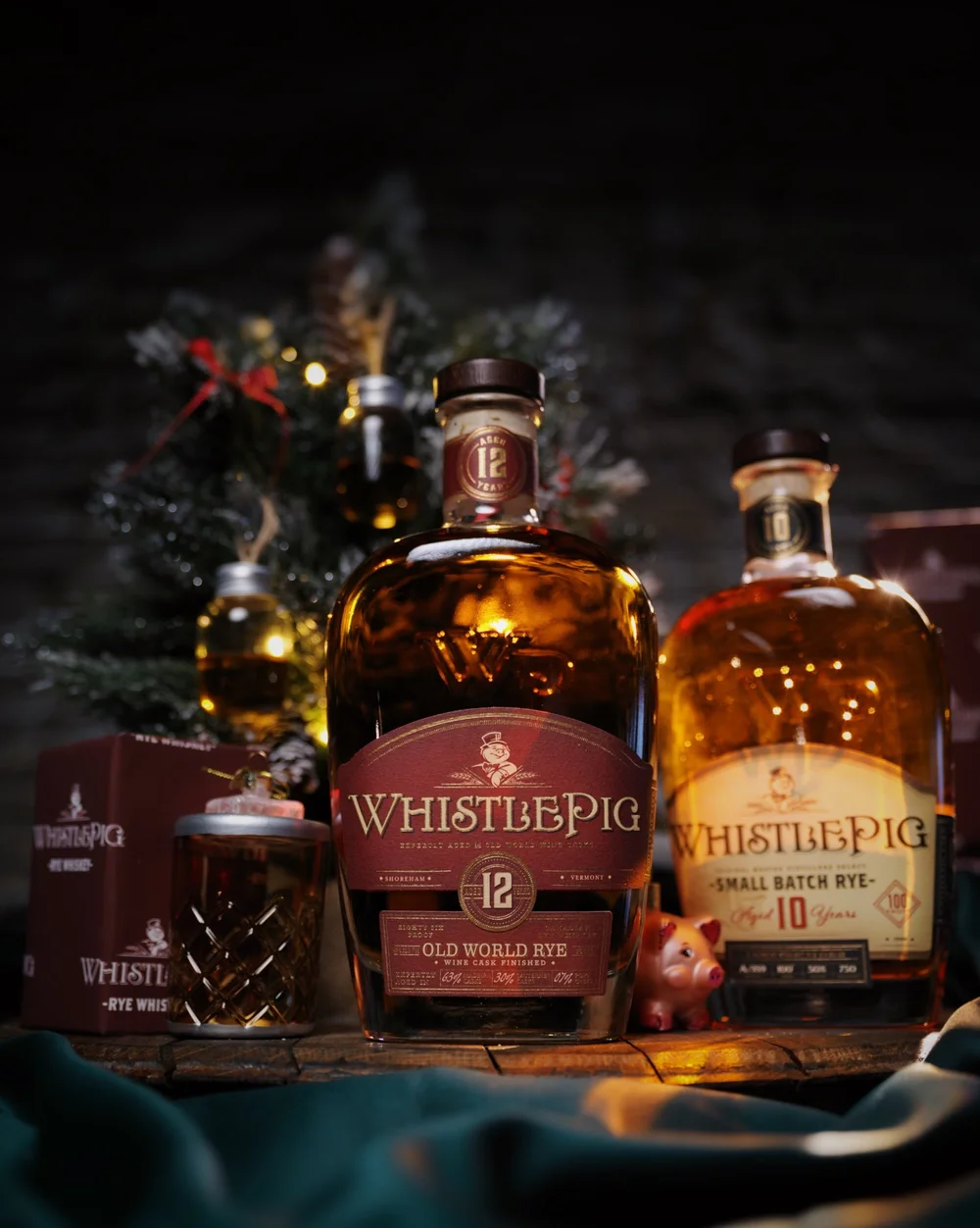 WhistlePig whiskey bottles with holiday greenery and warm lights