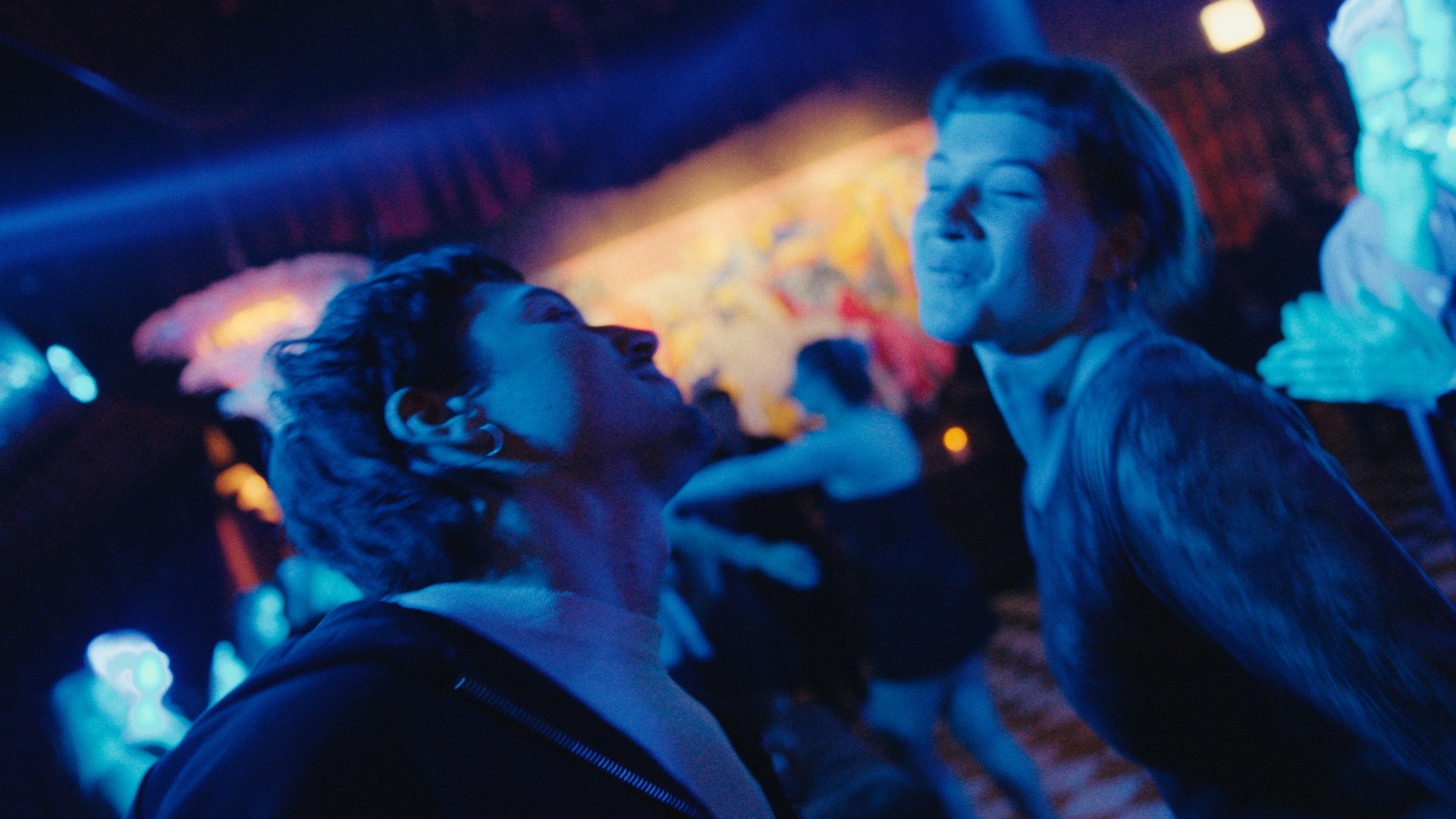 Two people in a vivid blue-lit cinematic scene