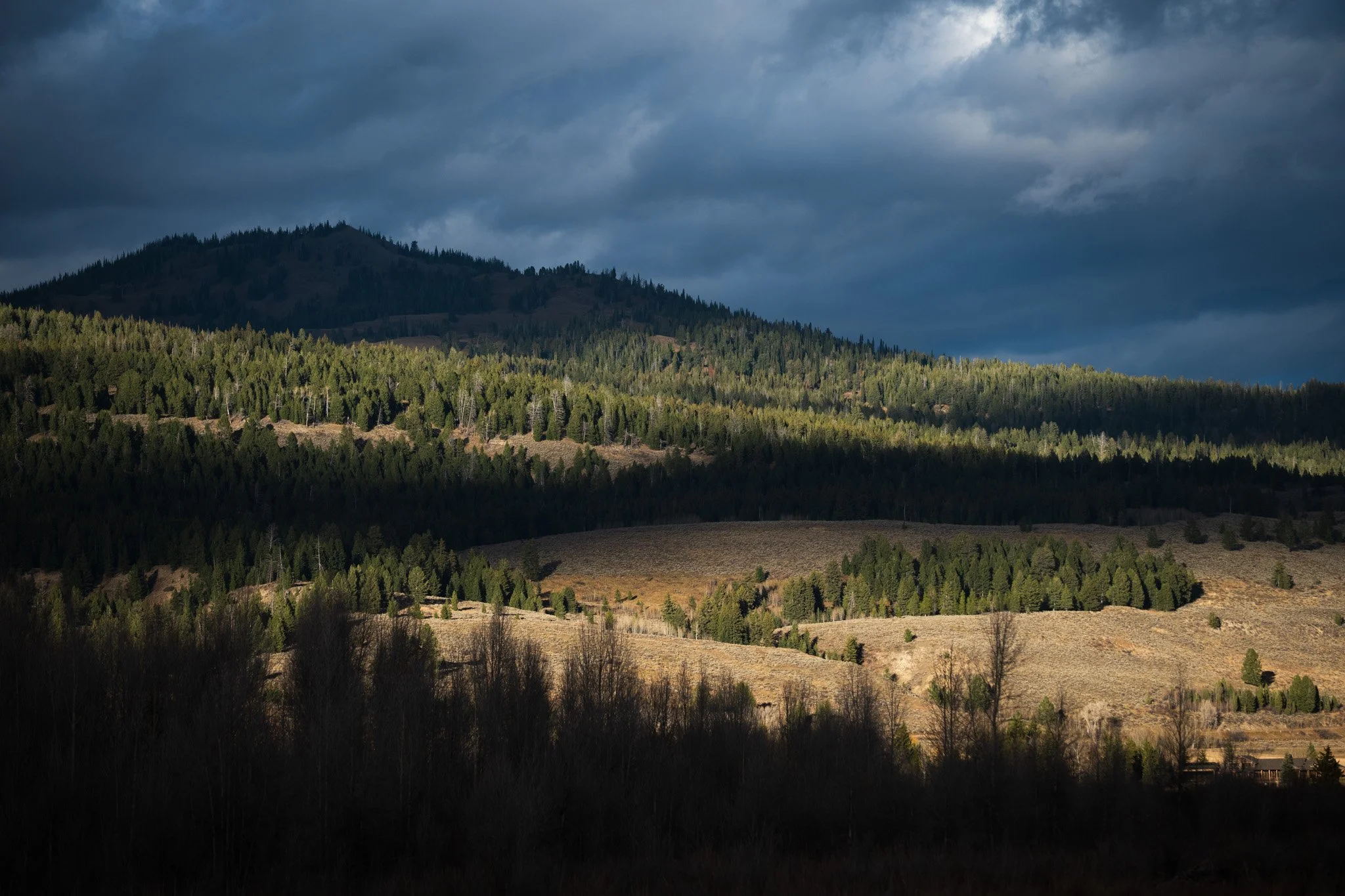 A band of sunlight across forested hills