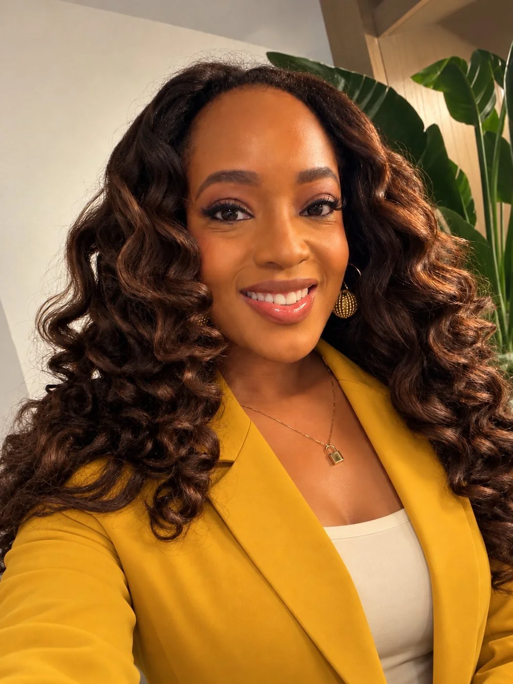 Cari Hawthorne smiling in a mustard blazer