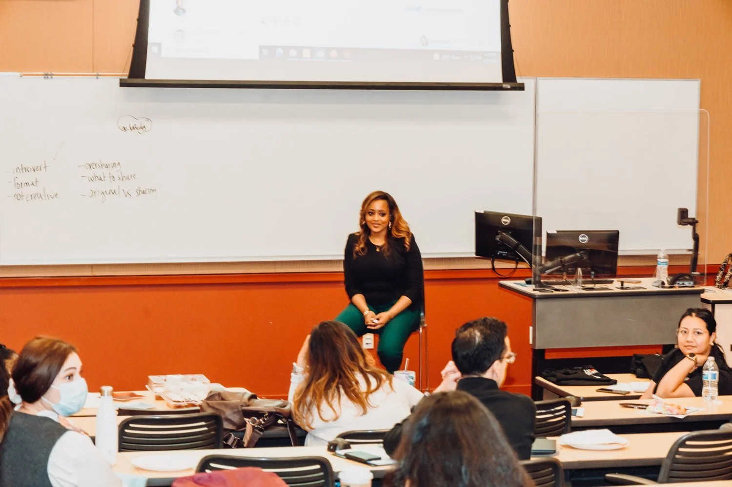 Cari leading a discussion with students in a university classroom
