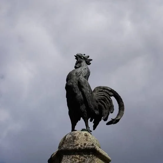 A rooster statue against the sky