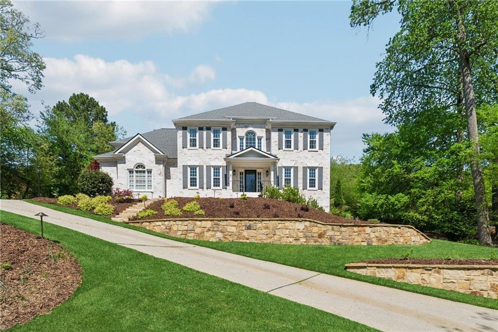 Front exterior view of 590 Kensington Farms Drive in Milton, Georgia with landscaped lawn.