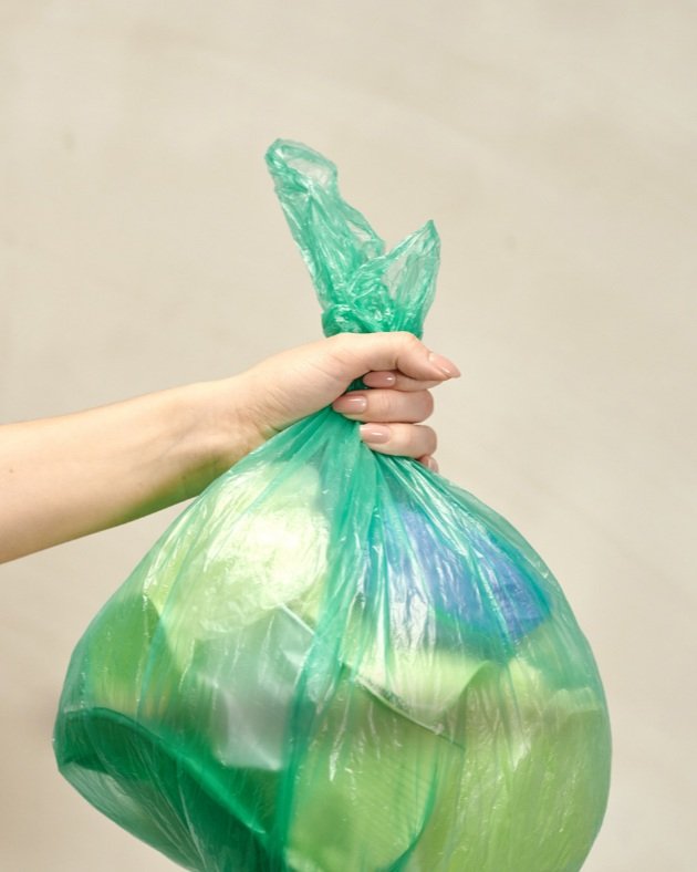 hand holding a bag of trash