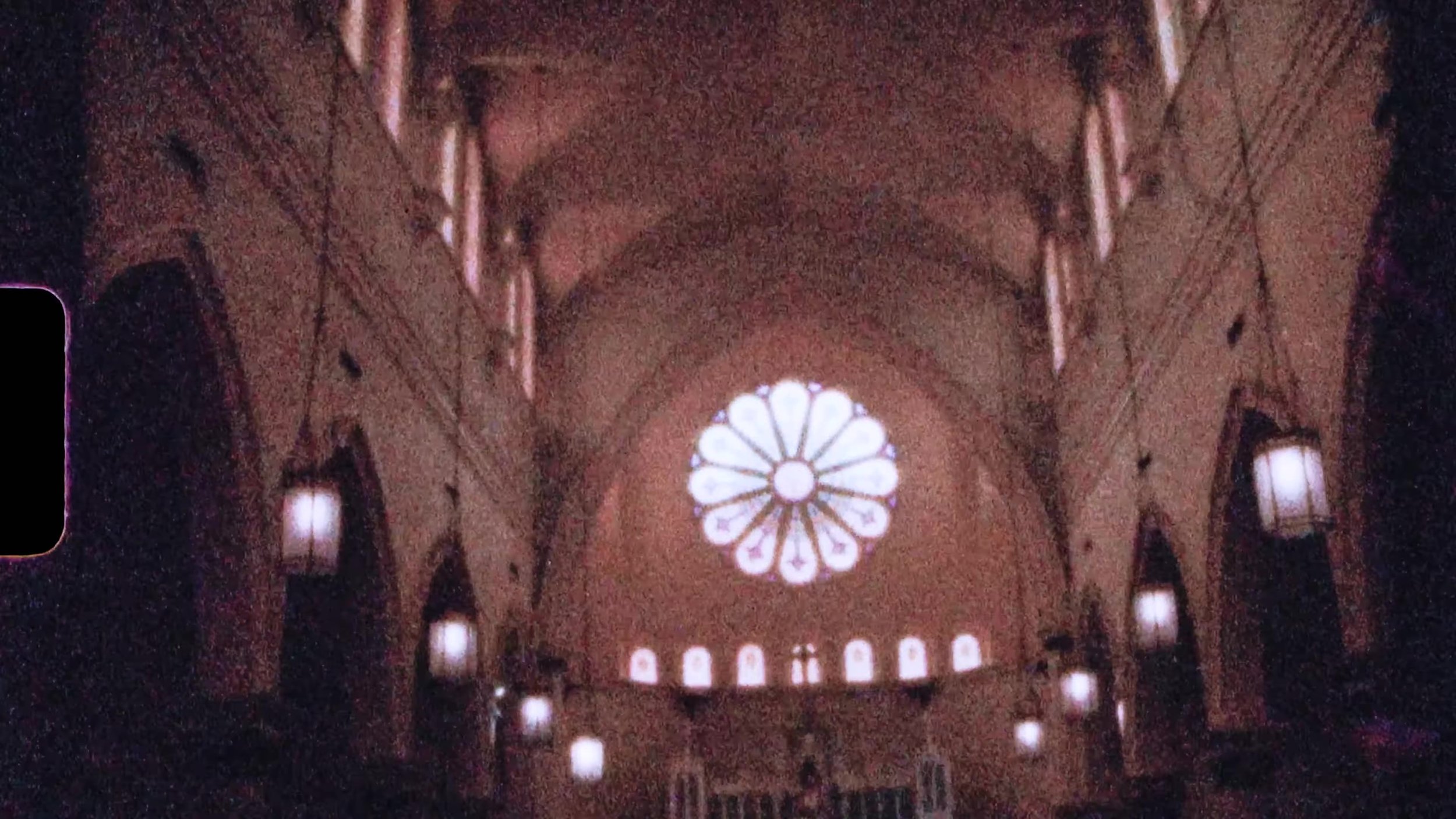 Wide film frame of church nave and rose window interior for a Houston wedding on 16mm