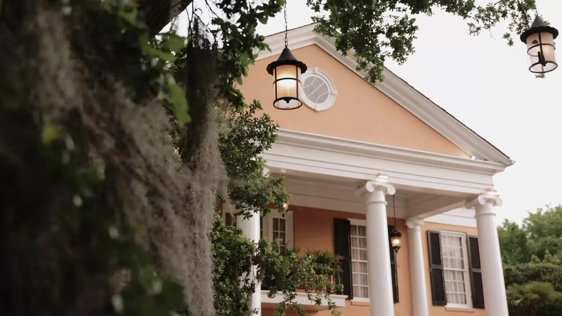 Southern Oaks Plantation mansion in New Orleans with white columns, Spanish moss, and glowing lanterns in the oaks