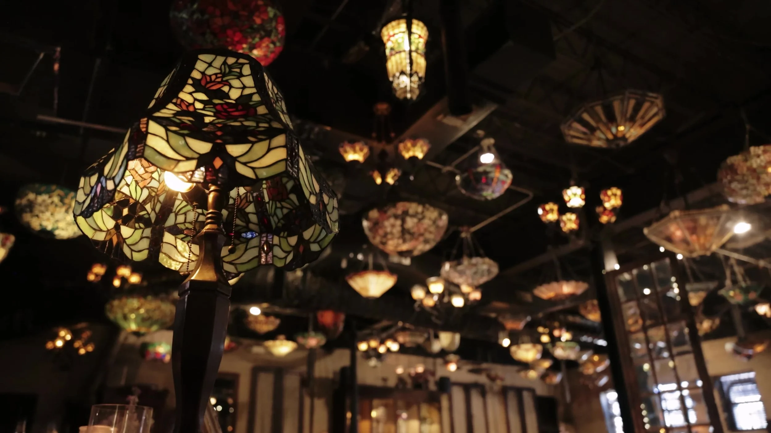 Close view of glowing Tiffany stained glass lamps hanging at Nouveau Antique Art Venue in Houston, Texas