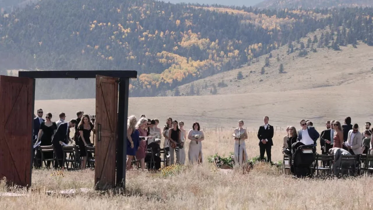 Open barn doors framing guests and autumn aspen on the mountain at 3 Peaks Ranch